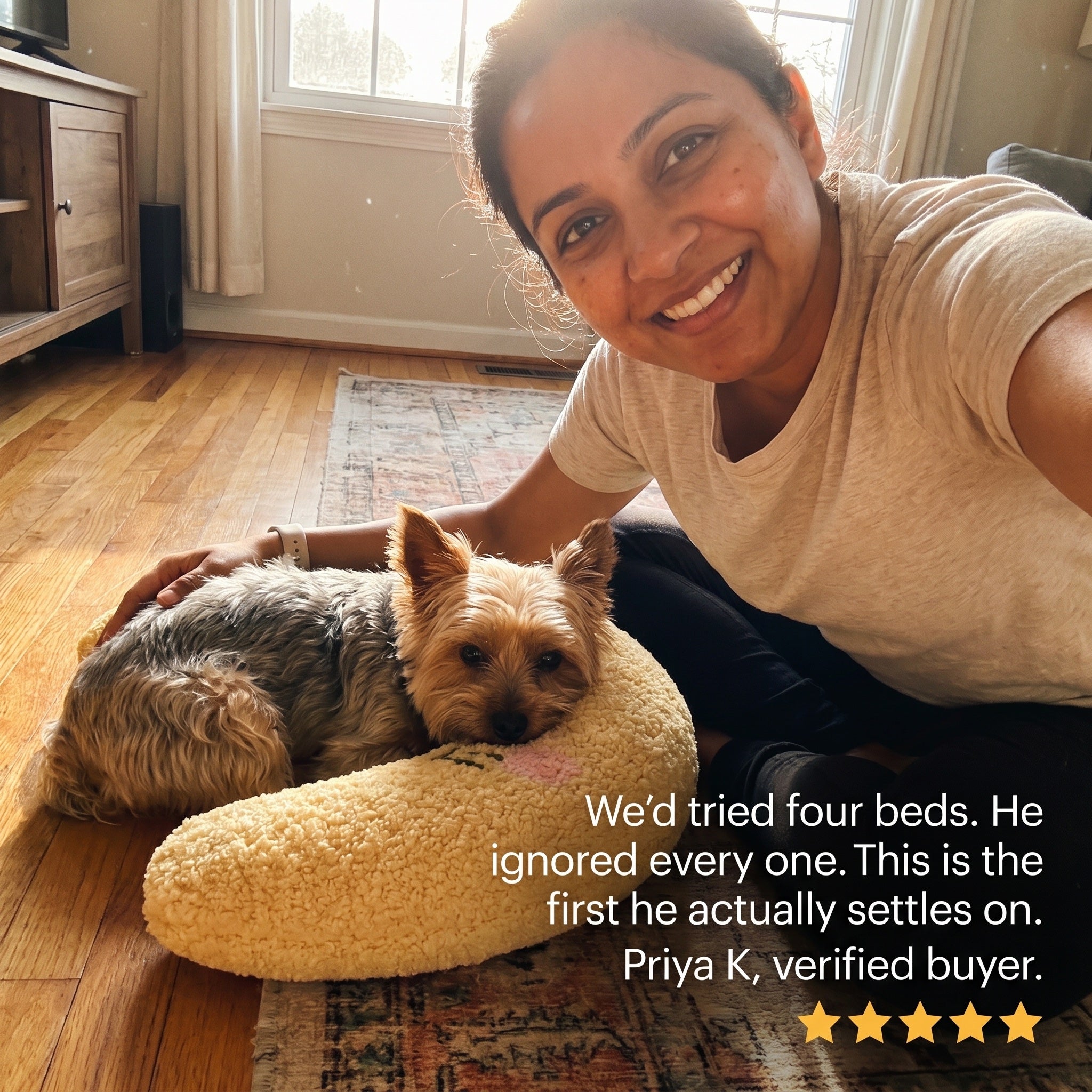 Priya beside her yorkie settling on a yellow PawCalm pillow, five-star review: we'd tried four beds, this is the first he actually settles on